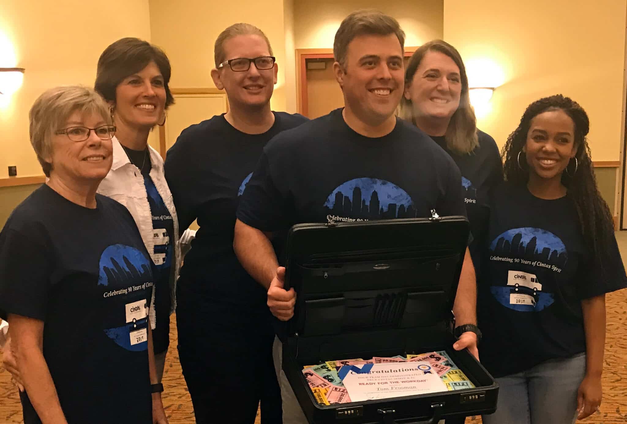 group of people posing with an open briefcase