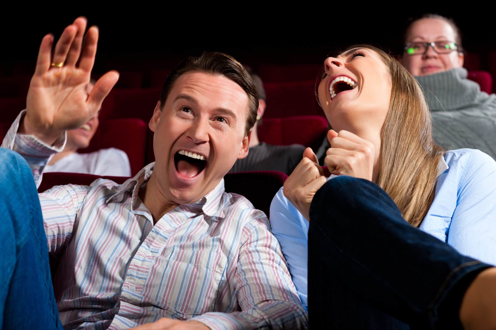 two people laughing in a theater
