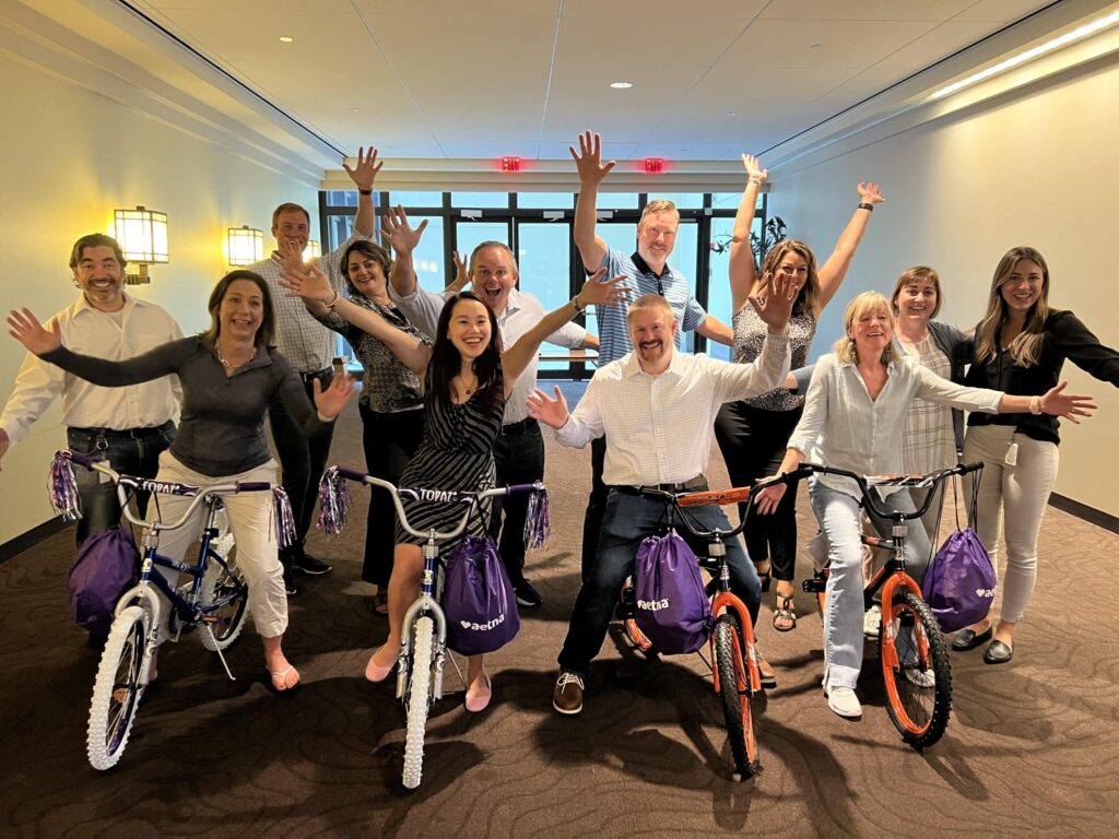 A happy team that just completed a successful Build-A-Bike team building game!